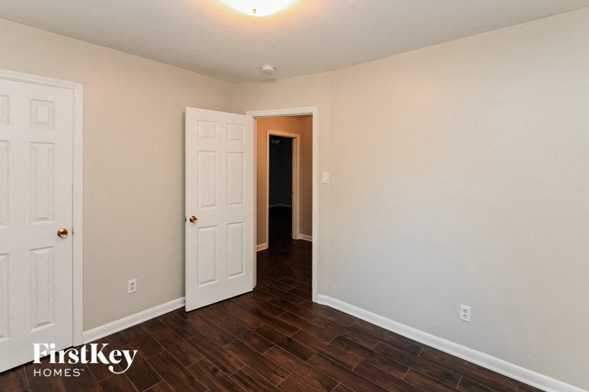 a bedroom with a white door and a hallway to a closet