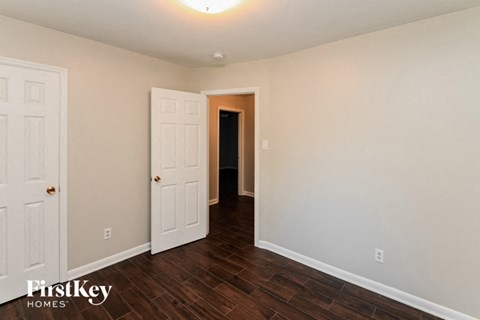 a bedroom with a white door and a hallway to a closet
