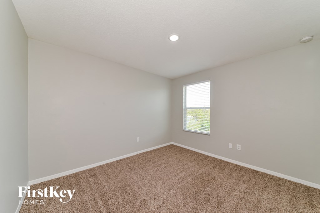 an empty room with carpet and a window
