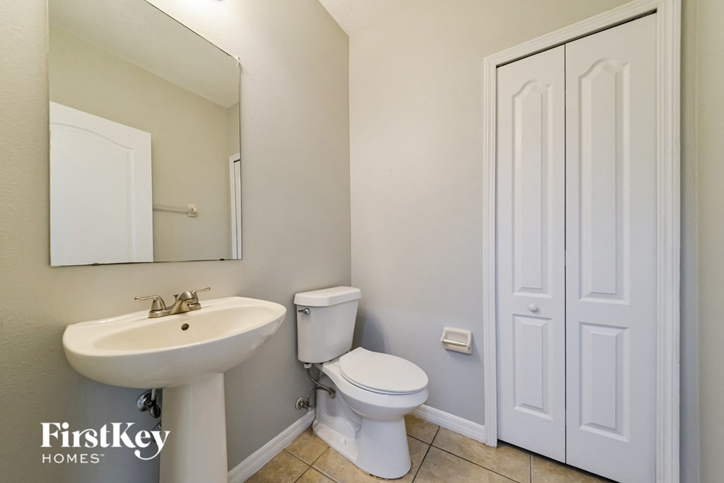 a bathroom with a sink toilet and a mirror