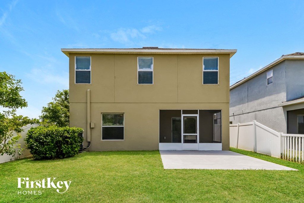 a beige house with a lawn and a sidewalk