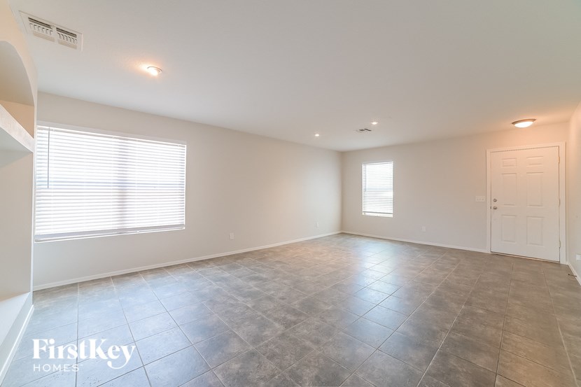 an empty living room with a white door and a window