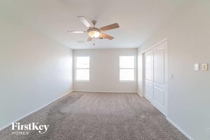 an empty room with a ceiling fan and a door