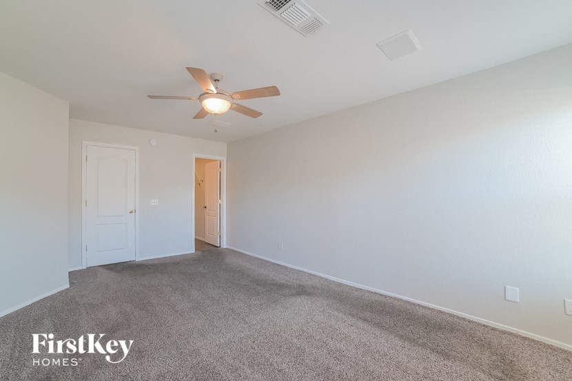 a living room with carpet and a ceiling fan