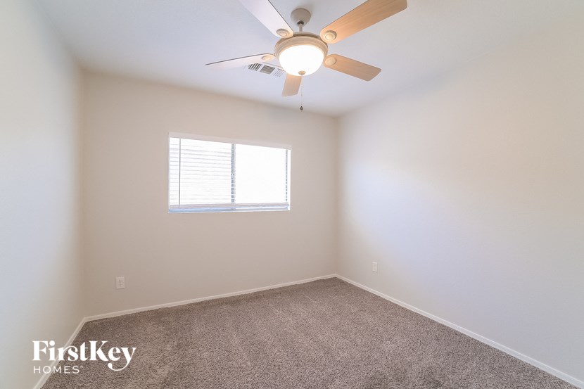 a bedroom with a ceiling fan and a window