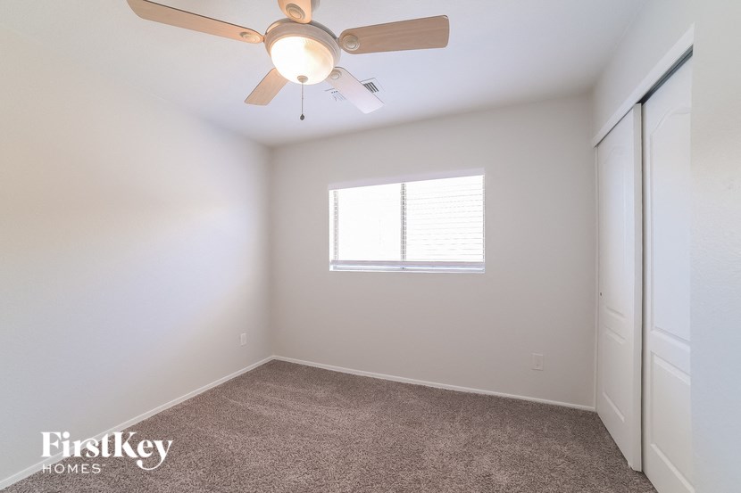 a bedroom with a ceiling fan and a closet