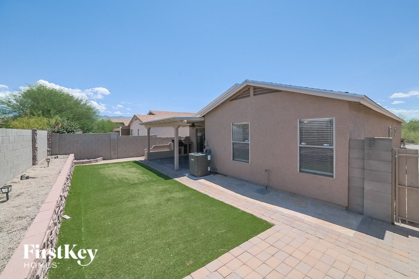a backyard with a house and a green lawn