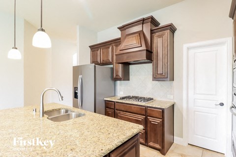 a kitchen with brown cabinets and a sink and a refrigerator