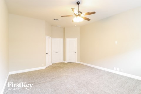 a bedroom with carpet and a ceiling fan