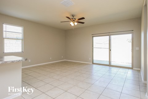A spacious room with a ceiling fan and sliding glass doors.