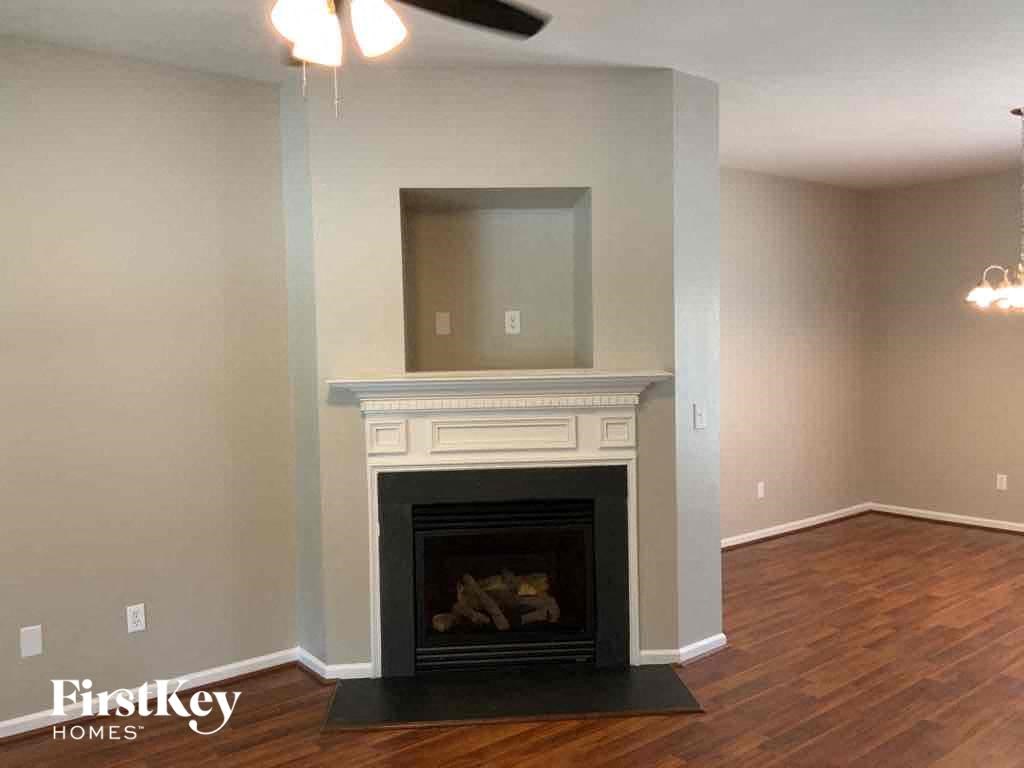 A living room with a fireplace and a tv above it.