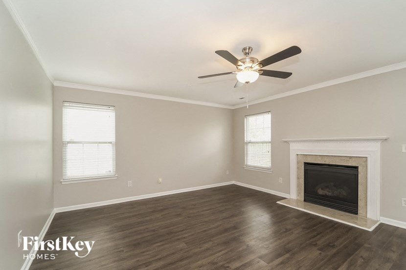 a living room with a fireplace and a ceiling fan