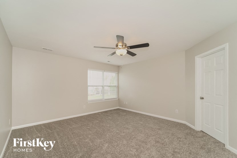 a bedroom with a ceiling fan and a window
