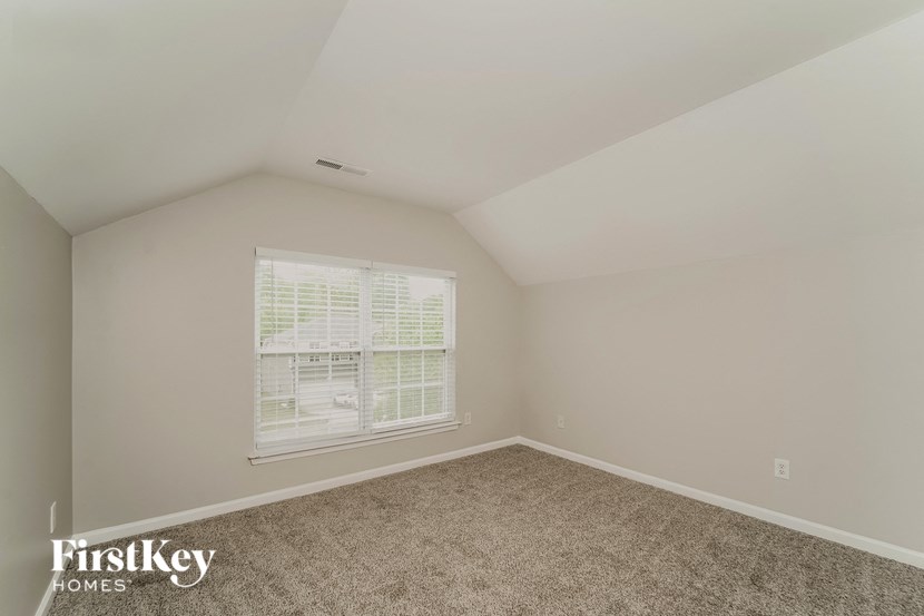 a bedroom with a large window and carpet