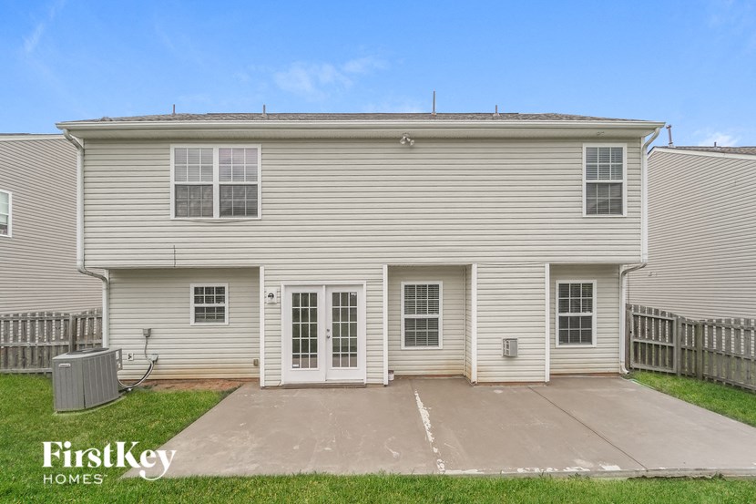 a white house with white siding and a driveway