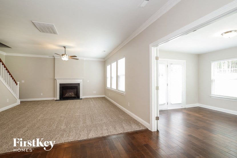 an empty living room with a ceiling fan and a fireplace