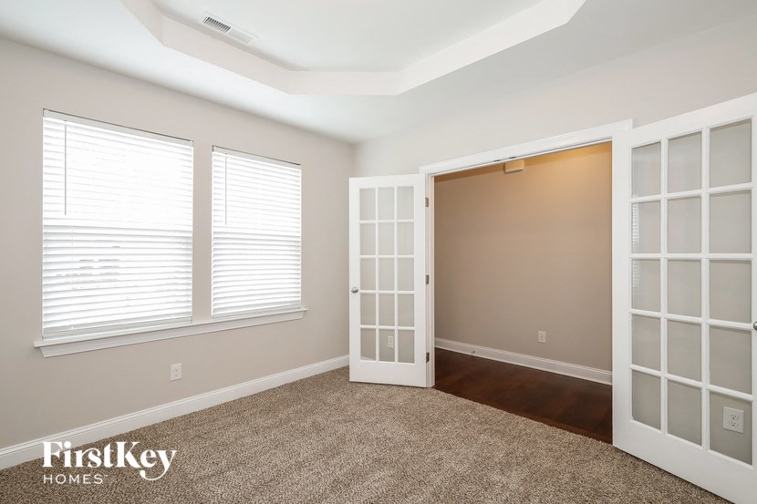 an empty room with three windows and a door
