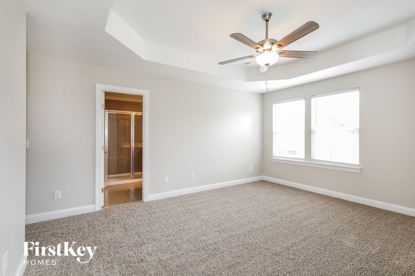 an empty living room with a ceiling fan