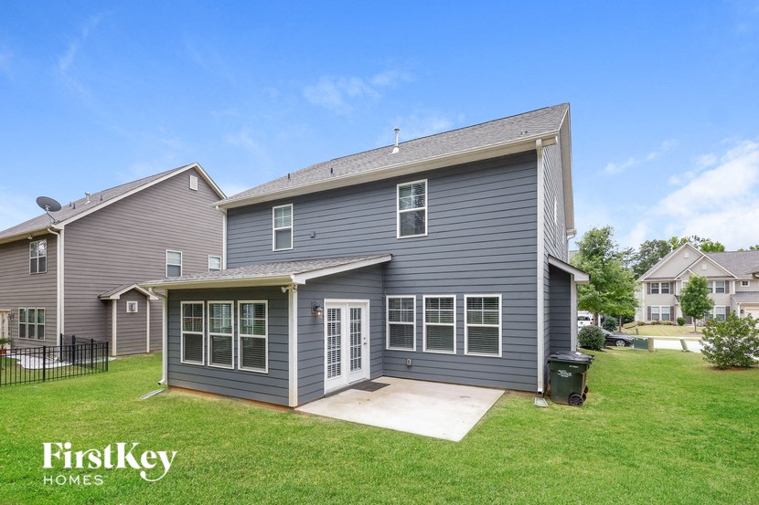 the front of a gray house with a yard and a driveway