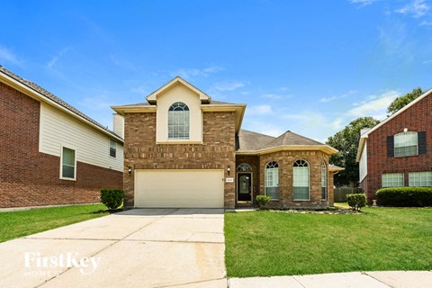 a brick house with a white garage door and a lawn