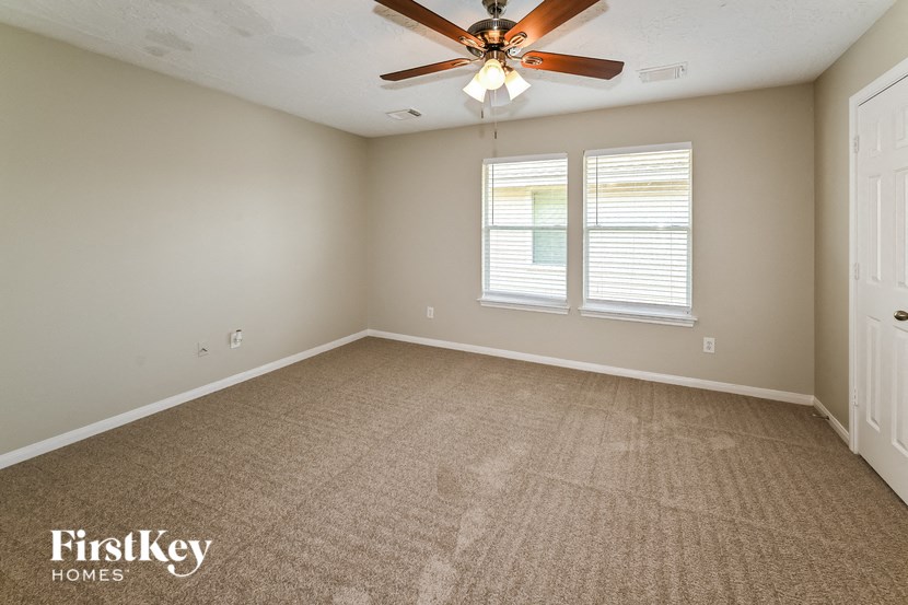 the living room of an empty house with a ceiling fan