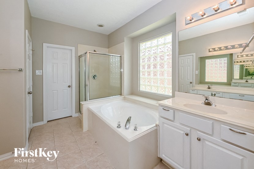 a bathroom with a large tub and a sink and a mirror