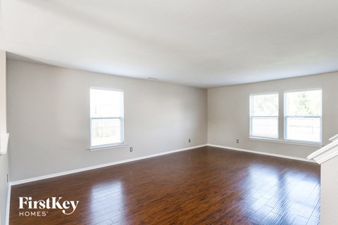 the living room of an empty house with wood floors