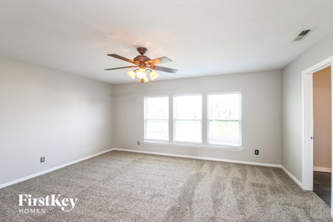 a bedroom with a ceiling fan and a large window