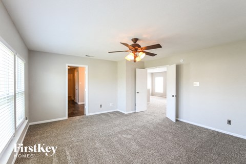a living room with carpet and a ceiling fan