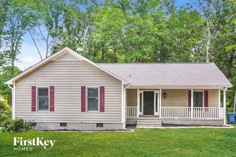 a small white house with red shutters and a porch