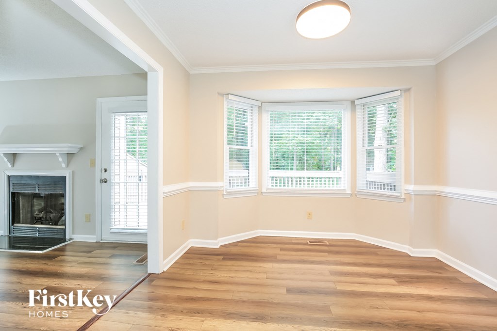 an empty living room with wood floors and a fireplace