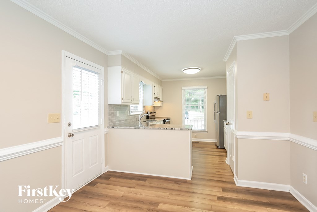 a kitchen with white walls and wooden floors and a kitchen island