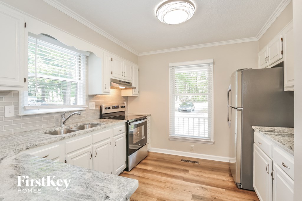 a kitchen with white cabinets and stainless steel appliances