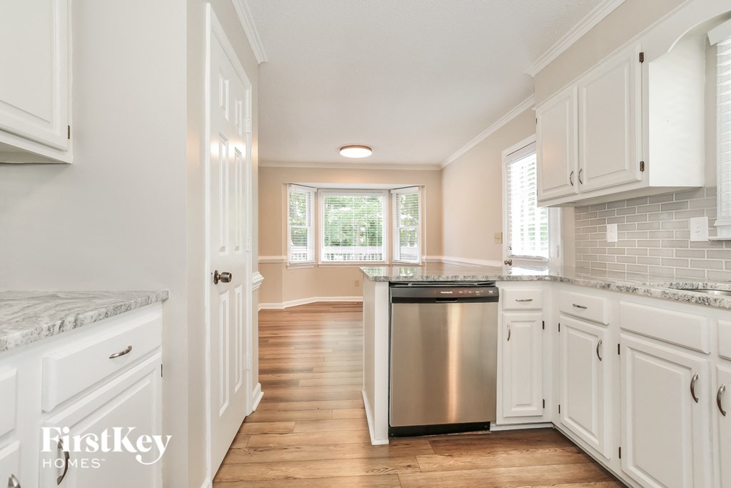 a kitchen with white cabinets and a stainless steel dishwasher