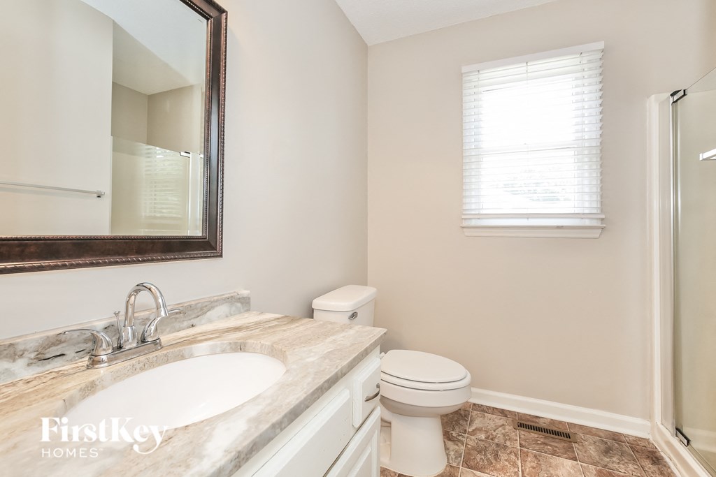a bathroom with a toilet and a sink and a mirror