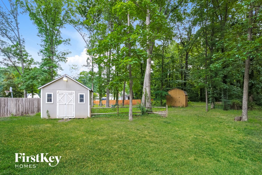 a backyard with a shed and a fence and trees