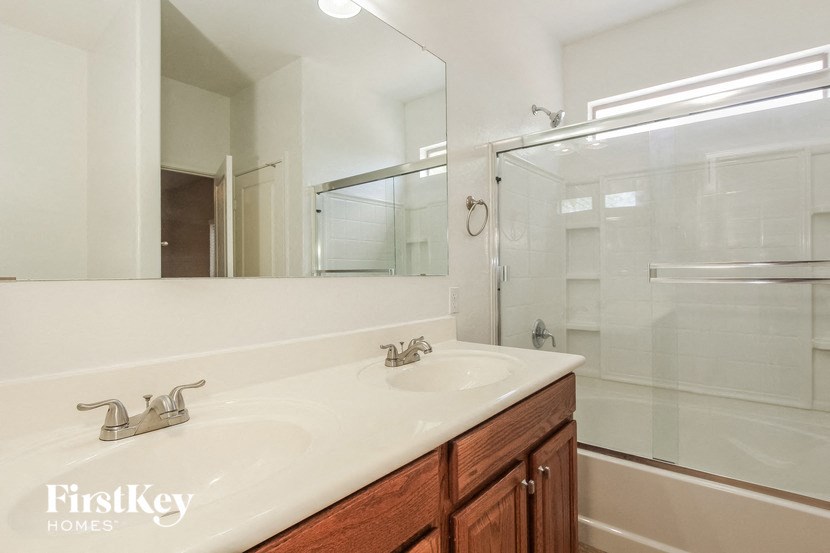a bathroom with a sink and a shower and a mirror