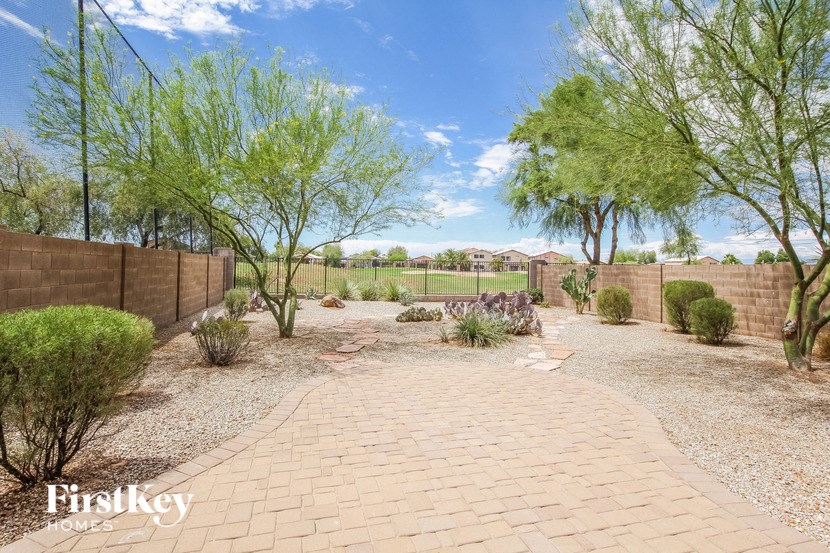 a garden with trees and a brick pathway