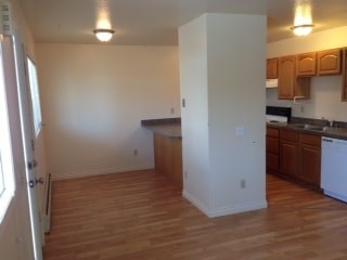 A kitchen with wooden floors and white walls.
