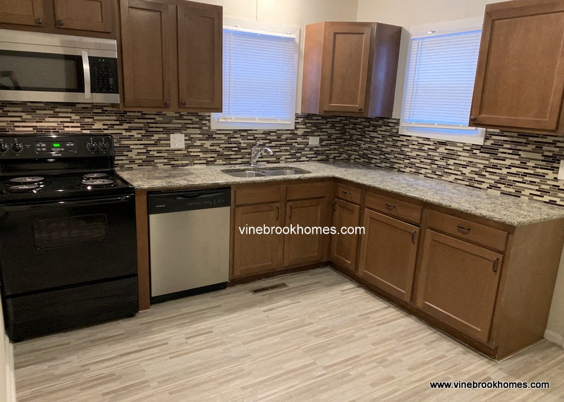 a kitchen with wooden cabinets and granite counter tops