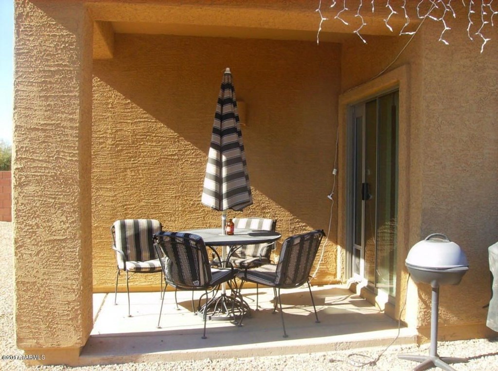 a patio with a table and chairs and an umbrella