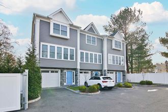 a large gray house with a white car parked in front of it