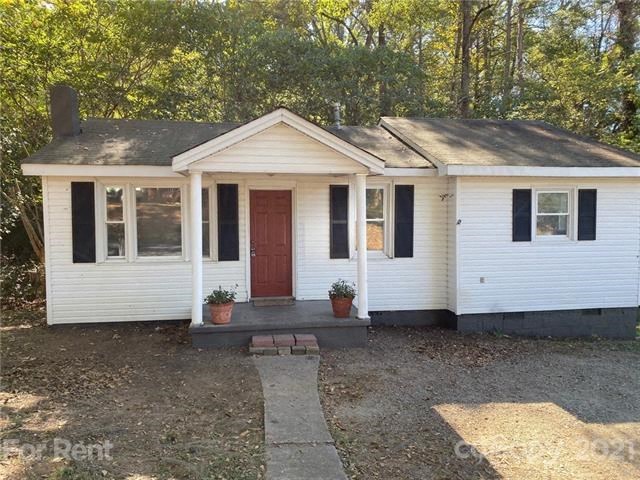 a small white house with a red door