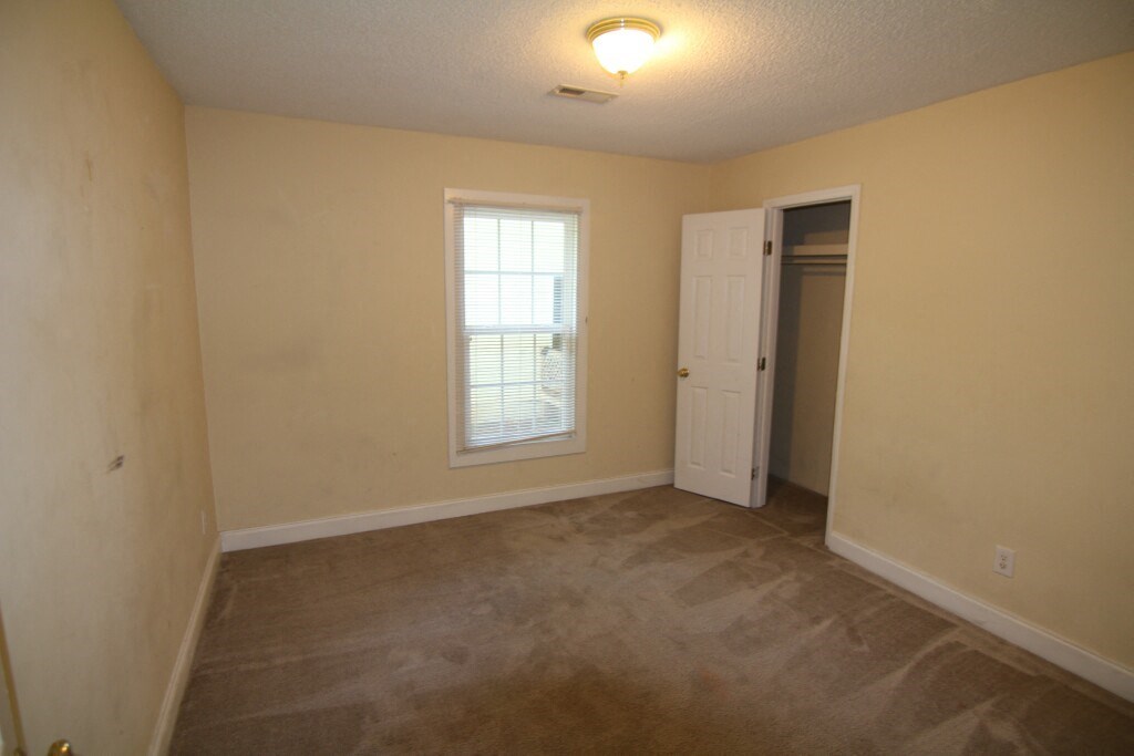 the living room of an empty house with a window and a door