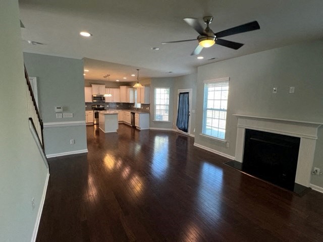 an empty living room with a ceiling fan