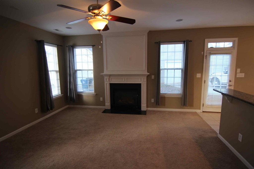 a living room with a fireplace and a ceiling fan