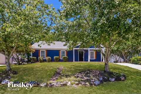 a blue house with trees in front of it