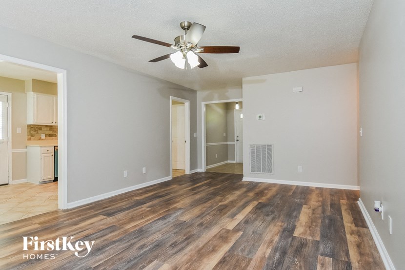 the living room and dining room with hardwood flooring and a ceiling fan