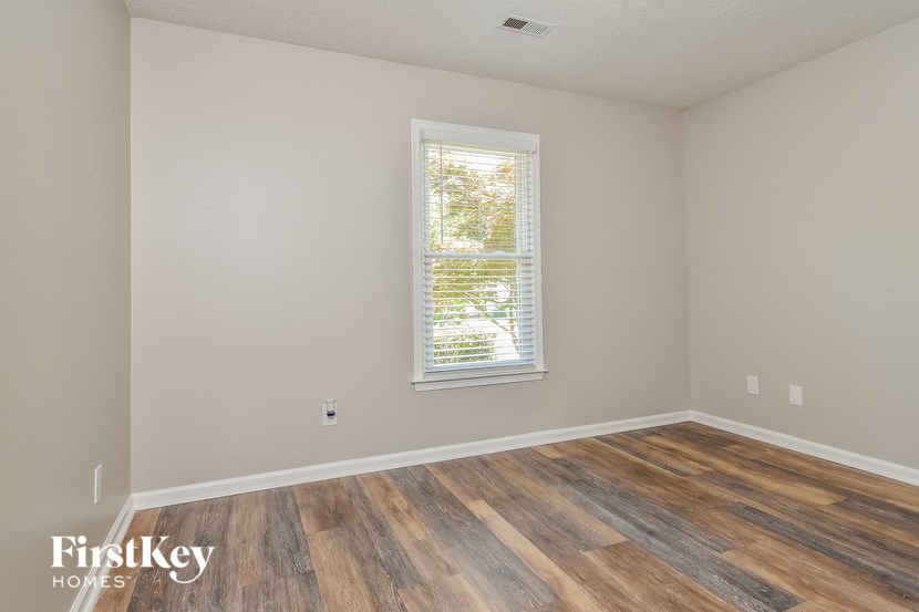 the living room of a house with wood floors and a window