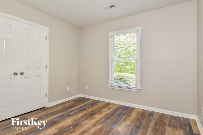 the living room of a home with wooden floors and a window